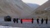 FILE - In this May 5, 2013, file photo, Chinese troops hold a banner which reads "You've crossed the border, please go back" in Ladakh, India. India says it is ready to hold talks with China with both sides pulling back their forces to end a standoff along a disputed territory high in the Himalayan mountains.