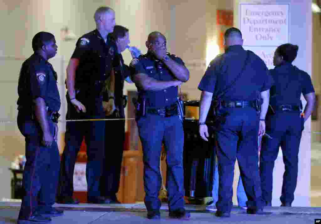 Un officier de police de Dallas pris d’émotion, couvre son visage avec une main, en compagnie de ses collègues à l’extérieur de la salle d'urgence du centre médical de l’université de Baylor, à Dallas, 8 juillet 2016. (AP Photo / Tony Gutierrez)
