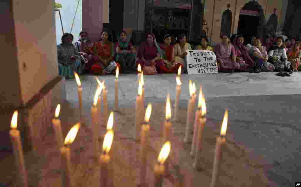 Perempuan-perempuan India berdoa untuk para korban gempa Nepal di sebuah kuil di Gorkha Nagar di Jammu, India (27/4). (AP/Channi Anand)