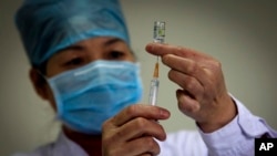 Seorang petugas medis menyiapkan dosis vaksin H1N1 pada awal program vaksinasi gratis untuk semua warga Beijing di sebuah klinik di Beijing, 16 November 2009. (Foto: dok).