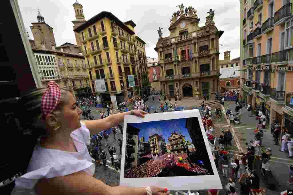 Cristina Esparza holds a San Fermin July 2019 photograph, in Pamplona, northern Spain, on the day the &#39;&#39;txupinazo&#39;&#39; would usually take place to start the famous San Fermin festival, which was canceled again this year due to the COVID-19 pandemic.