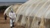Seorang anggota Pertahanan Sipil Suriah membersihkan tenda di kamp pengungsi di kamp Bab Al-Nour untuk mencegah penyebaran virus corona (COVID-19) di Azaz, Suriah, 26 Maret 2020. (Foto: Reuters)