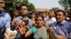 FILE - Journalists crowd around Asha Devi, mother of the victim of the fatal 2012 gang rape on a moving bus, after the Supreme Court verdict in the case, in New Delhi, India, May 5, 2017. 