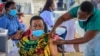 FILE - A woman receives a coronavirus vaccination at the Kololo airstrip in Kampala, Uganda, May 31, 2021. 