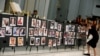 A woman places a photograph of one of the victims in the shooting at the Pulse gay nightclub, on a memorial during an Interfaith Service at First United Methodist Church in Orlando, Florida, June 14, 2016.