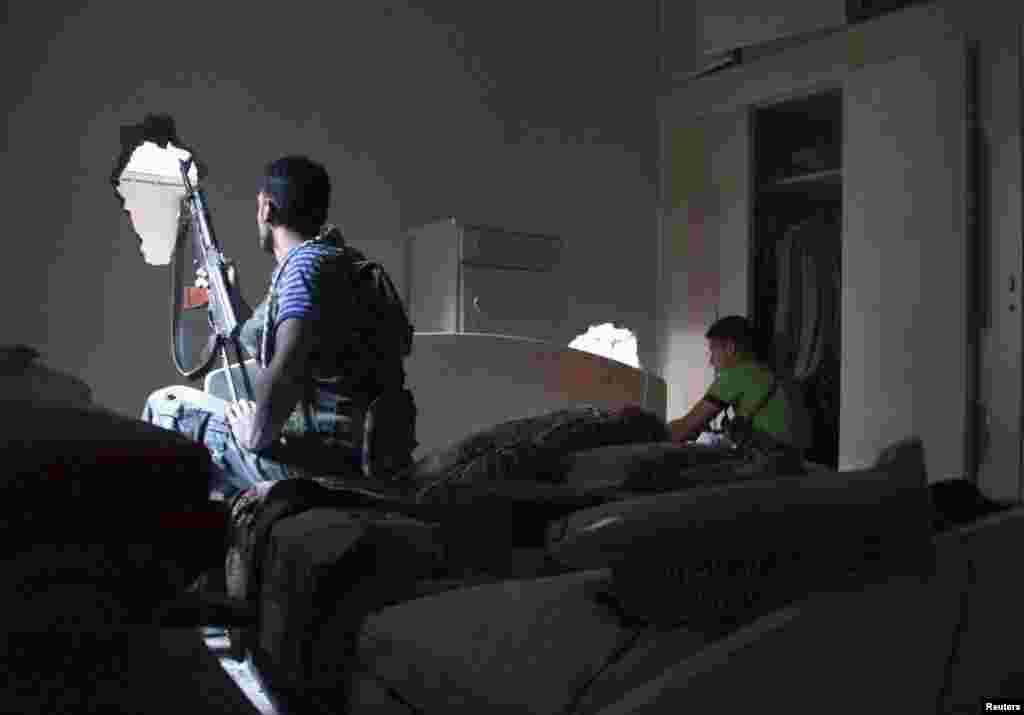Free Syrian Army members sit in a room inside a house in Deir el-Zor, May 16, 2013.