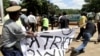 A Zimbabwean policeman struggles to confiscate a banner from a human rights activist on March 22,2013.