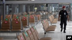 A security person patrols at Suvarnabhumi Airport in Bangkok, Friday, July 3, 2020. As the country starts to ease its travel restrictions allowing foreign visitors in on a controlled basis, a laboratory at the airport will have the results of COVID…
