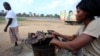 A woman dries bushmeat - which includes animals such as bats, antelopes, squirrels, porcupines or monkeys - along the highway near Yamoussoukro, Ivory Coast, March 29, 2014. 