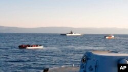 Un canot pneumatique avec des migrants, à gauche, dans l'étroite étendue d'eau entre l'île grecque de Lesbos et la côte turque, vendredi 2 avril 2021.