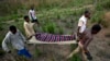 Des éléments de la Croix rouge transportent un mort sur une civière à Dungu, RDC, 17 février 2009.