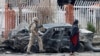 FILE - A member of Afghan security forces inspects a damaged vehicle at the site of a blast in Kabul, Afghanistan, Dec. 20, 2020. 