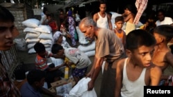 Des Rohingyas reçoivent de la nourriture dans un camp de déplacés à Sittwen Birmanie, le 24 avril 2014.