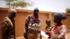Malian Armed Forces (FAMa) soldiers speak with a woman during the Operation Barkhane in Ndaki, Mali, July 29, 2019. 