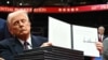 Predsjednik SAD-a Donald Trump drži jednu od izvršnih uredbi koju je potpisao tijekom inauguracijske parade u Capital One Areni, u Washingtonu. (Foto: Jim WATSON/AFP)
