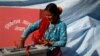 A woman smiles as she cast her vote on a ballot box during the parliamentary and provincial elections in Sindhupalchok District, Nepal, Nov. 26, 2017.