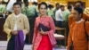 FILE - Myanmar opposition leader Aung San Suu Kyi, center, walks along with other lawmakers of her National League for Democracy party as they leave after a regular session of the lower house of parliament in Naypyitaw, Myanmar.