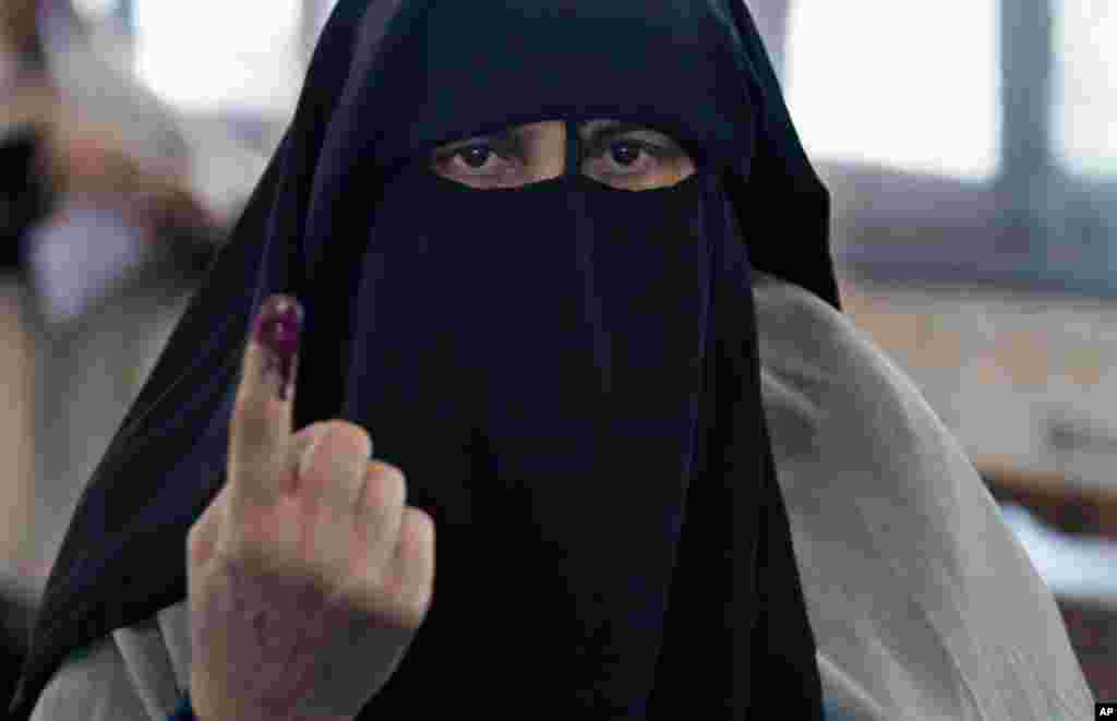 An Egyptian woman shows her inked after casting her vote during the first day of the presidential election in a polling station in Alexandria, Egypt, May 23, 2012.