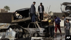 People inspect their destroyed cars at the scene of a car bomb attack in Ameen neighborhood in eastern Baghdad, Iraq, February 17, 2013.