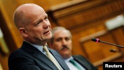 British Foreign Secretary William Hague speaks as Jordanian Foreign Minister Nasser Judeh (R) listens during their joint news conference before a meeting of the Friends of Syria alliance in Amman, May 22, 2013. 