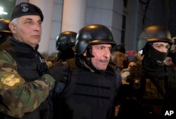 FILE - Former Public Works Secretary Jose Lopez, center, is escorted by police outside the police station in the outskirts of Buenos Aires, Argentina, June 14, 2016.