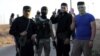 FILE - Rebels from the Hayat Tahrir al-Sham group are seen near buses, outside the villages of al-Foua and Kefraya, Idlib province, Syria, July 18, 2018. 