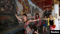 FILE - Chinese tourists pose for a picture inside the Grand Palace in Bangkok.