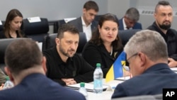 Na fotografiji koju je omogućila američka vojska, ukrajinski predsjednik Volodymyr Zelenskyy, u sredini, sluša dok posjećuje tvornicu municije Scranton Army u Scrantonu, Pennsylvania, 22. septembra 2024.