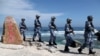 FILE - Soldiers of China's People's Liberation Army (PLA) Navy patrol at Woody Island, in the Paracel Archipelago, which is known in China as the Xisha Islands, Jan. 29, 2016. Fewer than 10 jets – a combination of Shenyan J-11 and Xian JH-7 aircraft – have been spotted on Woody Island.