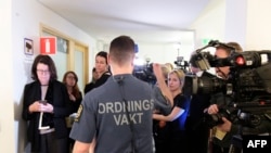 Un agent de sécurité se tient devant les journalistes lors de l'ouverture du procès de Rakhmat Akilov, devant le tribunal de Stockholm, le 13 février 2018.