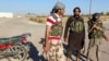 Islamic State fighters stand along a street in the countryside of the Syrian Kurdish town of Kobani, after taking control of the area, Oct. 7, 2014.