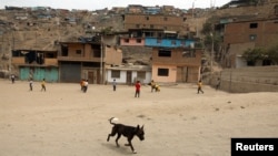 FILE - Children play soccer in the shanty town Nueva Esperanza on the outskirts of Lima, Peru, April 4, 2018.