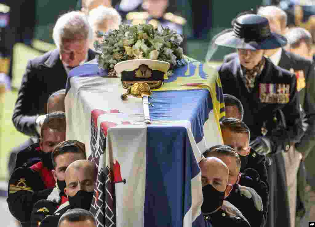 Pall bearers carrying the coffin of the Duke of Edinburgh, followed by the Prince of Wales, left and Princess Anne, right, into St. George&#39;s Chapel for his funeral, at Windsor Castle, in Windsor, England, April 17, 2021.