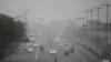 Vehicles move through morning smog on the last day of a two-week experiment to reduce the number of cars to fight pollution in New Delhi, India, Jan. 15, 2016. 