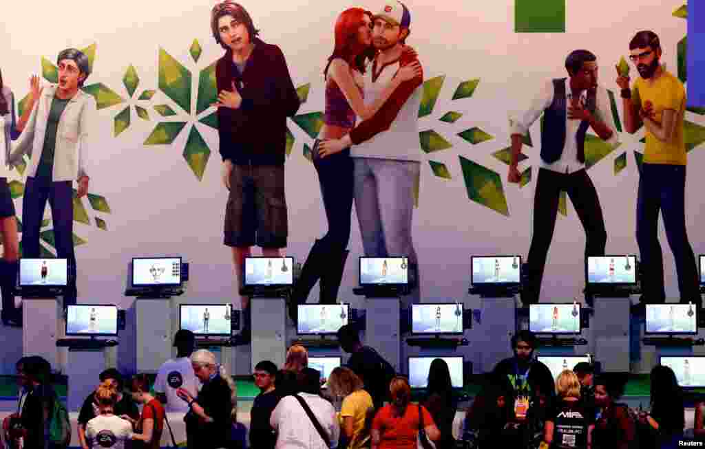 Para pengunjung memainkan "Sims 4" di salah satu stand pameran elektronik dalam acara Gamescom 2013 di Cologne, Germany.