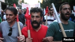 Demonstran anti-Euro berpawai melewati jalanan dalam reli anti penghematan di Athena, Yunani, 15 Juli 2015.