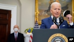 Presidenti Joe Biden heq maskën ndërsa përgatitet të flasë për daljen në pension të gjyqtarit të Gjykatës së Lartë, Stephen Breyer, majtas, në dhomën Roosevelt të Shtëpisë së Bardhë në Uashington, 27 janar 2022.