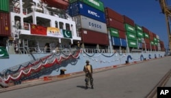 FILE - A Pakistan soldier stands guard while a loaded Chinese ship prepares to depart Gwadar port, about 700 kilometers (435 miles) west of Karachi. Pakistan, Nov. 13, 2016.