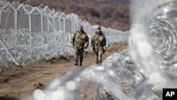 Des soldats macédoniens patrouillent à côté de deux lignes de barrière de protection située le long de la frontière entre la Macédoine et la Grèce, près de la ville du sud de la Macédoine de Gevgelija, 4 mars 2016. (AP Photo / Visar Kryeziu)