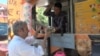 After considerable searching, Masooq Dowlati found work at a food truck. While he continues to look for an office job, he hopes to stay on with the truck. (J. Soh/VOA)