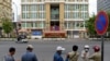 FILE - Security personnel stand across the street in front of Phnom Penh Municipal Court, Aug. 1, 2020.