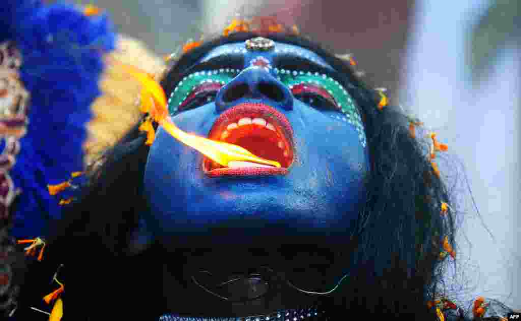 Seorang seniman India berpakaian seperti Dewi Hindu Kali memeriahkan perayaan festival Ram Navami, memperingati hari kelahiran&nbsp;Dewa Rama di kota Allahabad.