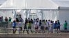 FILE - Detained migrant children from Central America line up to enter a tent at the Homestead Temporary Shelter for Unaccompanied Children in Homestead, Florida, Feb. 19, 2019. 