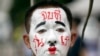 Seorang demonstran pro-demokrasi dengan cat wajah bertuliskan 'Akhiri dengan generasi kita' saat melakukan protes di Universitas Thammasat di Pathum Thani, utara Bangkok, Thailand, Senin, 10 Agustus 2020. (Foto: AP)