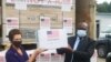 Ellen Thorburn remettant un lot de vaccins à Jean Ignace Tendele, directeur de cabinet du ministre de la Santé, Brazzaville, le 26 août 2021.