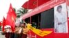 Supporters holding flags of Myanmar opposition leader Aung San Suu Kyi's National League for Democracy party stand as a Myanmar artist sings a song on campaign truck during an election campaign in Yangon, Oct. 7, 2015.