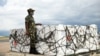 FILE - A Malawian policeman guards AstraZeneca COVID-19 vaccines after the shipment arrived at the Kamuzu International Airport in Lilongwe, March 5, 2021.
