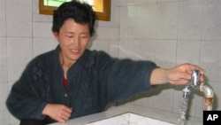 북한 평양 인근의 한 농장에서 외부 지원으로 지어진 급수시설을 사용하는 북한 주민. (자료사진)