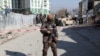 FILE - An Afghan security officer stands guard at the site of a bomb blast in Kabul, Afghanistan, Dec. 15, 2020. Another explosion on Dec. 18, 2020, killed at least 15 civilians in eastern Ghazni province, Afghan officials reported. 