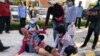 A woman lies on the floor after security guards broke up a small protest near the Chinese embassy opposing alleged plans to boost Beijing's military presence in the country, in Phnom Penh, Cambodia October 23, 2020. (REUTERS/Heng Mengheang) 